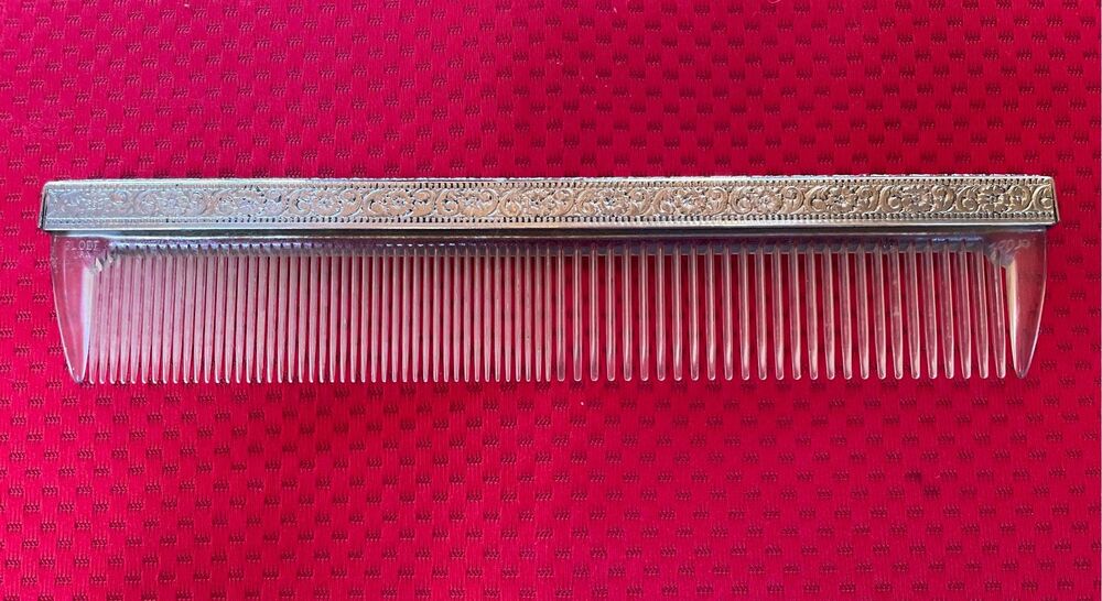 Vintage Globe USA plastic hair comb featuring an ornate, embossed metal spine co